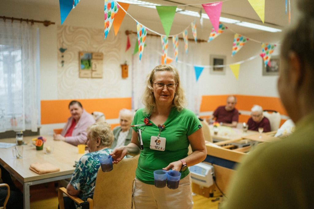 Caregiver serving beverages to elderly residents in cheerful San Antonio nursing home